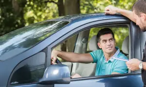 Agente mostra un verbale a un automobilista, forse per assicurazione scaduta e multa.