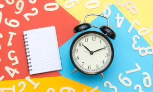 Sulla scrivania, numeri sparsi, un quaderno e una sveglia indicano che si può cambiare assicurazione prima della scadenza annuale.