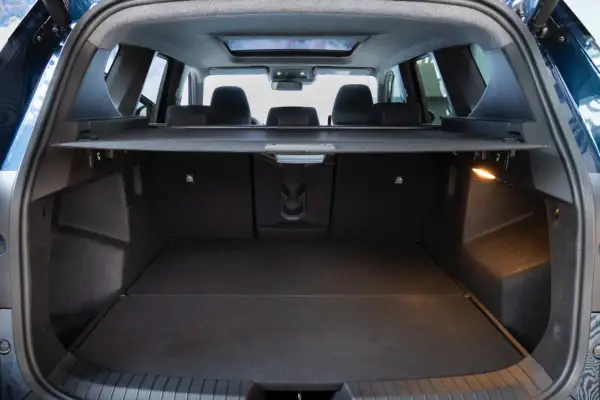 Bagagliaio aperto della Dacia Bigster, con sedili posteriori abbassati. Le dimensioni generose promettono spazio per ogni avventura.