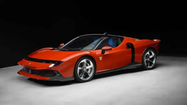 Iconica Ferrari 849 Testarossa arancione, con interni blu, su sfondo scuro.