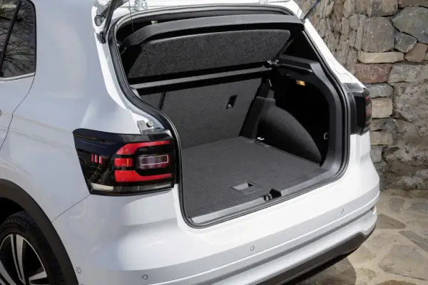 Bagagliaio aperto di un'auto bianca, con un'ampia capacità di carico, perfetta per ogni tipo di viaggio, anche con bagagli di grandi dimensioni.